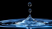 Water drop collision creating crown splash formation with suspended droplets above rippling blue surface in dramatic lighting against black background.