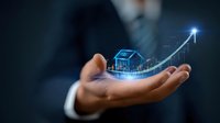 Glowing digital house with rising arrow graph floating above businessman's palm, representing real estate market growth and property investment success.