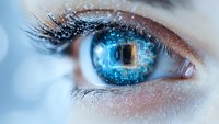 Macro shot of bright blue eye with digital technology effect, sparkles and binary code reflections showing future vision and artificial intelligence concept.