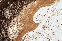 Abstract liquid art background with swirling brown and white colors, coffee foam texture with bubbles and splashes creating dynamic fluid pattern.