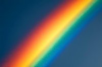 Vibrant rainbow spectrum with red, orange, yellow, green, blue, indigo, and violet bands against a deep blue background.