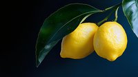 Fresh yellow lemons with green leaves on dark background, ideal for food photography, cooking blogs, and citrus-themed designs.