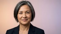 Professional mature Asian businesswoman with gray hair in black blazer smiling confidently against gradient background for corporate presentations.