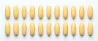 Overhead view of pale yellow oval capsules arranged in two neat rows on white background for pharmaceutical or supplement packaging.