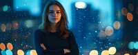 Young woman with crossed arms against blurred city lights and bokeh background at night, creating atmospheric moody portrait with blue tones and golden highlights.