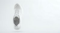 White perforated sneaker floating on light background, top view. Minimalist athletic footwear concept for sport and fashion design projects.