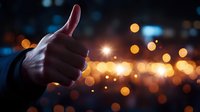 Silhouette of thumbs up gesture against blurred city lights and bokeh background at night, representing success, approval, and positive feedback.