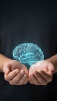 Glowing digital brain hologram floating above cupped hands representing artificial intelligence, mental health, neuroscience and cognitive technology concepts.