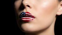 Woman with American flag painted on lips showing patriotic makeup art for Independence Day celebrations and national holidays.