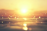 Golden sunset over calm water surface with magical bokeh lights floating in warm evening air, creating dreamy atmospheric scene for relaxation backgrounds.