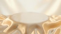 Elegant golden silk fabric draped around white podium platform for luxury product display and premium brand presentation in soft lighting.