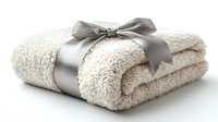 Soft plush cream colored towel rolled and tied with elegant gray satin ribbon bow on white background, spa and wellness concept for bathroom decor.