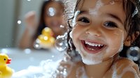 Happy child playing with yellow rubber duck in bubble bath, showing bright smile with wet curly hair and soap suds, joyful bathing moment captured in natural light.