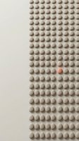 Beige spheres arranged in grid pattern with one red sphere standing out among uniform rows, representing uniqueness and individuality in business concepts.
