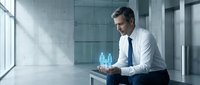 Professional businessman in white shirt analyzing holographic data visualization in modern office environment for technology and business presentations.
