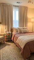 Cozy modern bedroom with warm lighting, beige curtains, comfortable bed and stylish decor for relaxation and sleep.