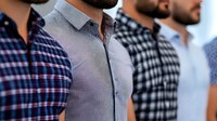 Diverse group of men wearing casual button-up shirts in plaid and checkered patterns standing in line, cropped view showing torso details. Perfect for fashion retail.