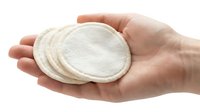 Hand holding reusable cotton facial pads on white background. Eco-friendly skincare rounds for makeup removal, isolated for design.
