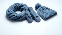 Blue knitted winter accessories set with cable pattern scarf, mittens and beanie hat isolated on white background for seasonal fashion design.