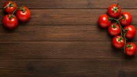 Fresh ripe red tomatoes on vine against dark wooden background, arranged in corners creating copy space for text in rustic style layout.