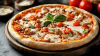 Fresh homemade pizza with melted mozzarella, ground meat, cherry tomatoes and basil leaves on wooden board against dark background, close up view.