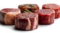 Fresh raw beef tenderloin filet mignon steaks with rosemary on white background, isolated cuts of premium red meat ready for grilling.