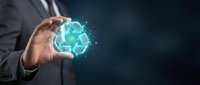 Businessman hand holding glowing turquoise recycling symbol with digital particles on dark background representing sustainability and environmental responsibility.