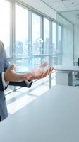 Businessman presenting digital technology icons and data analytics in modern office environment with city view through large windows.