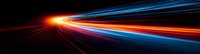 Abstract light trails on black background with red, orange and blue streaks creating dynamic motion effect suggesting high speed movement and technology advancement.