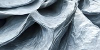 Smooth flowing curves and layers create abstract organic shapes in light blue and gray tones, resembling natural rock formations or glacial ice textures.