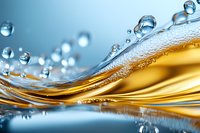 Dynamic wave of golden liquid with pure water drops creating abstract pattern against blue background with mirror reflection and macro details.