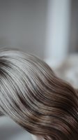 Close-up of healthy brown hair with natural highlights showing smooth texture and shine in soft natural light for beauty and haircare concepts.