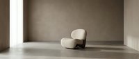 Minimalist interior space featuring a modern cream-colored upholstered armchair with wooden base positioned in empty room with concrete walls and polished floor, suitable for furniture design, interior styling, and architectural visualization projects.