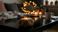 Cozy living room with coconut shell candle on coffee table, warm fairy lights creating ambient atmosphere for relaxation and home decor.