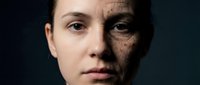 Young woman face showing aging process with wrinkled skin transformation on dark background for skincare and anti-aging treatment concepts.