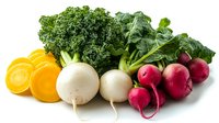 Fresh organic vegetables arranged in rainbow order with sliced carrots, white turnips, kale leaves and red radishes on white background, isolated for easy design use.