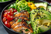 Grilled teriyaki salmon bowl with fresh avocado slices, cherry tomatoes and black sesame seeds served on dark plate. Healthy protein-rich lunch.