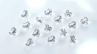 Collection of brilliant cut diamonds scattered on white background for jewelry design and luxury marketing materials.