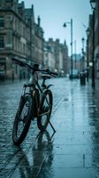Bicycle parked on wet cobblestone street in rainy urban setting with historic architecture and street lamps, suitable for transportation and city lifestyle concepts.