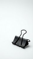 Black metal binder clip isolated on white background for office supplies, document organization, and business stationery designs.