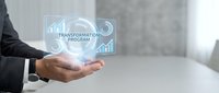 Businessman holding digital transformation program hologram with growth charts and analytics icons for business strategy and innovation concepts.