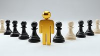 Golden figure stands out among black and white chess pawns representing leadership, uniqueness and strategic thinking in business concepts.