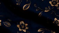 Elegant floral and paisley pattern in gold on navy blue fabric texture. Luxurious oriental motifs create sophisticated seamless design for fashion and home decor.