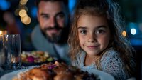 Smiling young girl with curly hair at holiday dinner table with bearded father in background, festive bokeh lights and roasted turkey meal.