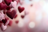 Pink and burgundy heart shapes floating on blurred romantic background with bokeh lights create dreamy Valentine's Day or love concept atmosphere.