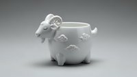 White ceramic sheep-shaped mug with decorative patterns on neutral background for kitchen and dining concepts.