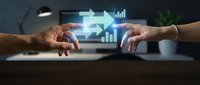 Hands of two professionals exchanging glowing digital arrows and growth charts, symbolizing business partnership, data transfer, and financial success in modern workplace.