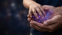 Cupped hands holding glowing purple light particles with magical sparkles and energy effects against dark background for fantasy and spiritual concepts.