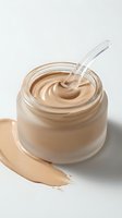 Creamy beige foundation makeup in glass jar with applicator wand and product smear on white background for cosmetic advertising and beauty campaigns.