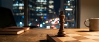 Wooden chess piece on board with cityscape bokeh lights visible through office window at night, suitable for strategy, business planning, leadership and corporate concepts.
